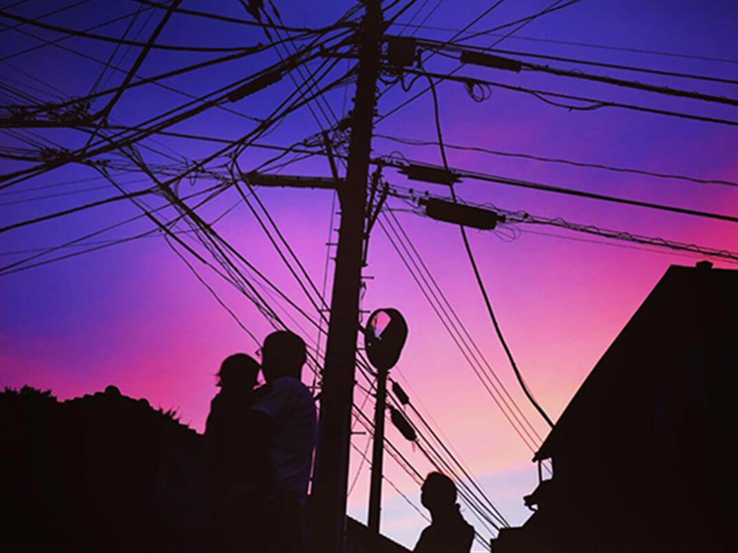夕焼を背景に人物、家電線のシルエットの風景写真